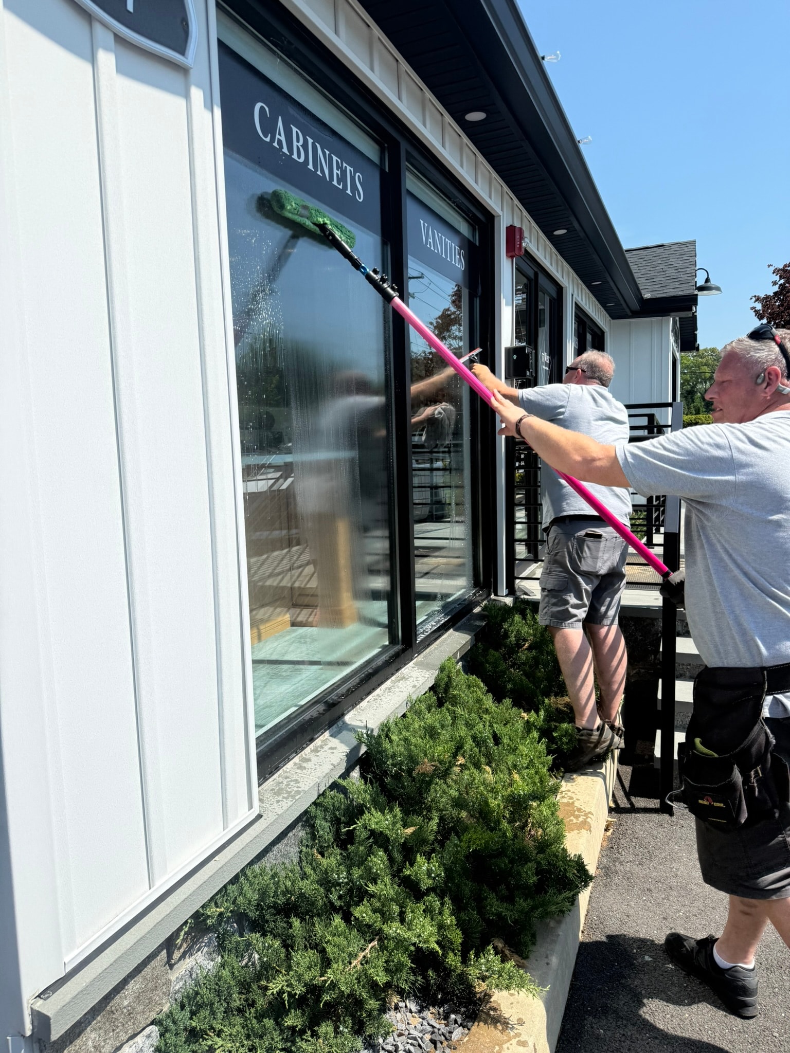 Man cleaning storefront windows with brush