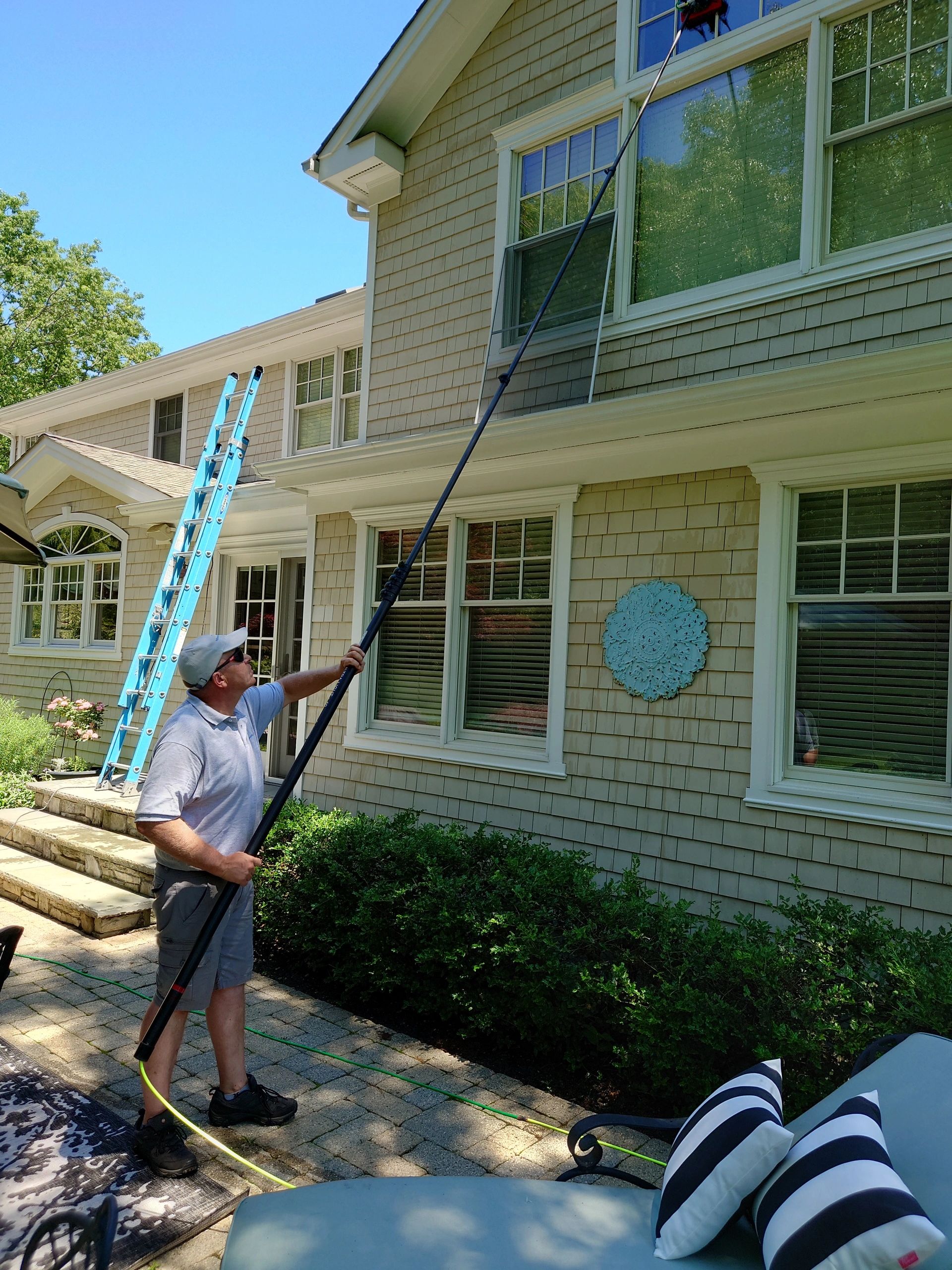 Man cleaning house exterior windows